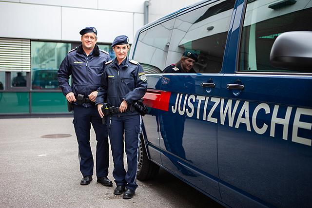 Zwei Personen der Exekutive vor einem Kleinbus